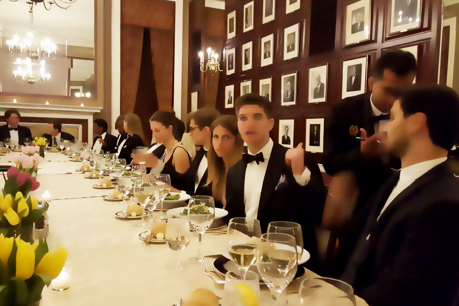 A black-tie salon dinner in a portrait-lined hall